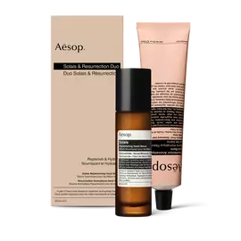 Eine Pumpflasche Solais Replenishing Hand Serum und eine Tube Resurrection Aromatique Hand Balm zusammen in einem   Karton.