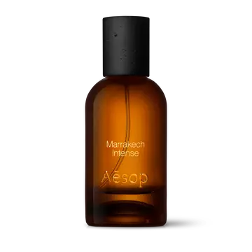 Bernsteinfarbene Flasche des Aesop Marrakech Intense Eau de Parfum aus Glas mit schwarzem Verschluss vor weißem Hintergrund.