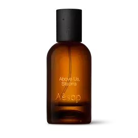 Bernsteinfarbene Flasche des Aesop Above Us, Steorra Eau de Parfum aus Glas mit schwarzem Verschluss vor weißem Hintergrund.