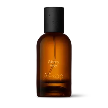Bernsteinfarbene Flasche des Aesop Silently Hwyl Eau de Parfum aus Glas mit schwarzem Verschluss vor weißem Hintergrund.