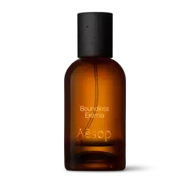 Bernsteinfarbene Glasflasche von Aesop Boundless Eremia Eau de Parfum mit schwarzem Verschluss vor weißem Hintergrund.