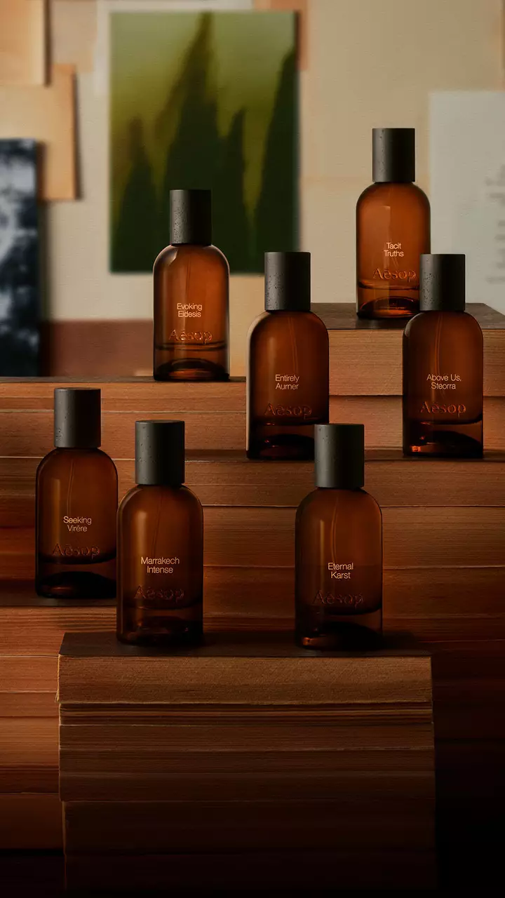 Aesop Parfumflaschen aus Bernsteinglas auf gestapelten Buchern.