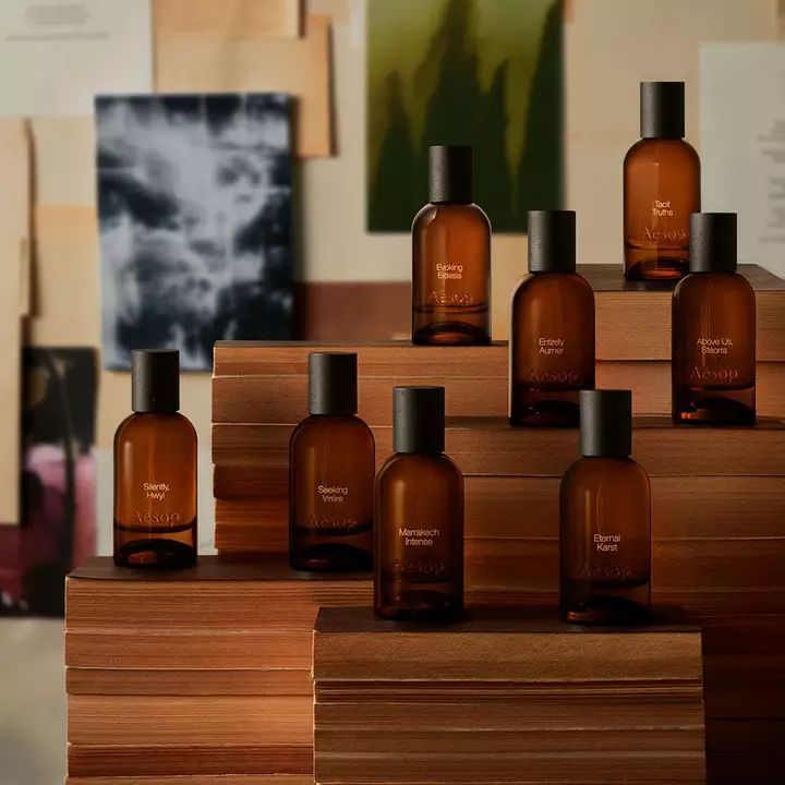 Aesop Parfumflaschen aus Bernsteinglas auf gestapelten Buchern.